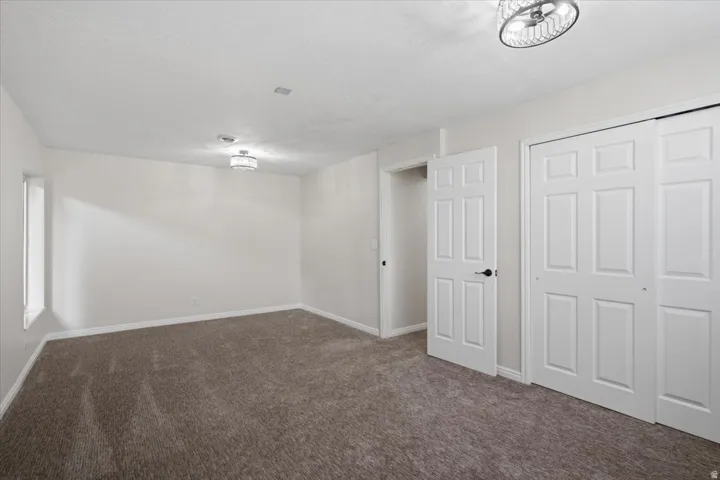 Spacious room featuring neutral carpeting, white walls, and two contemporary flush-mount light fixtures