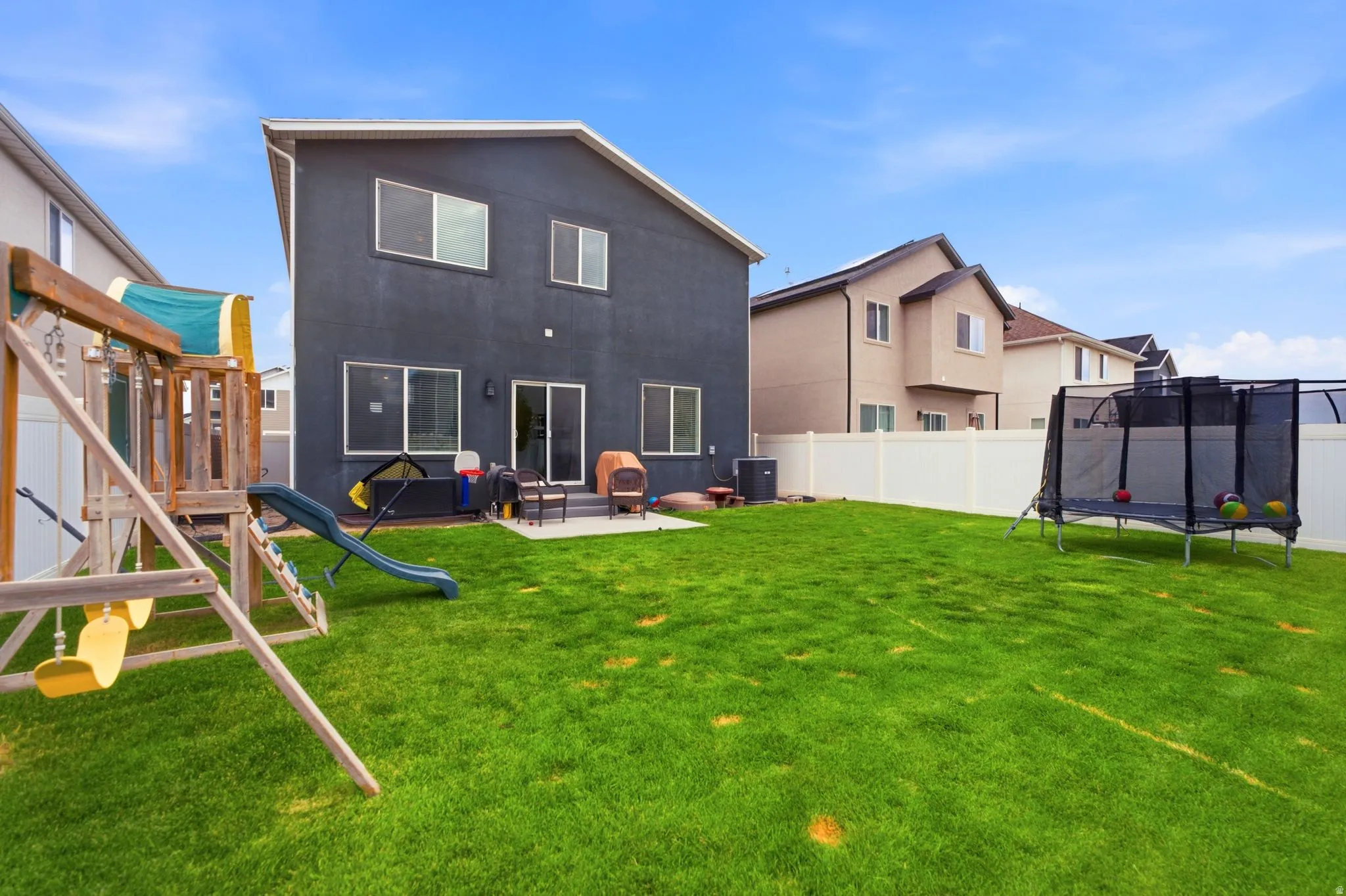Spacious backyard featuring a manicured lawn, a concrete patio, and a privacy fence