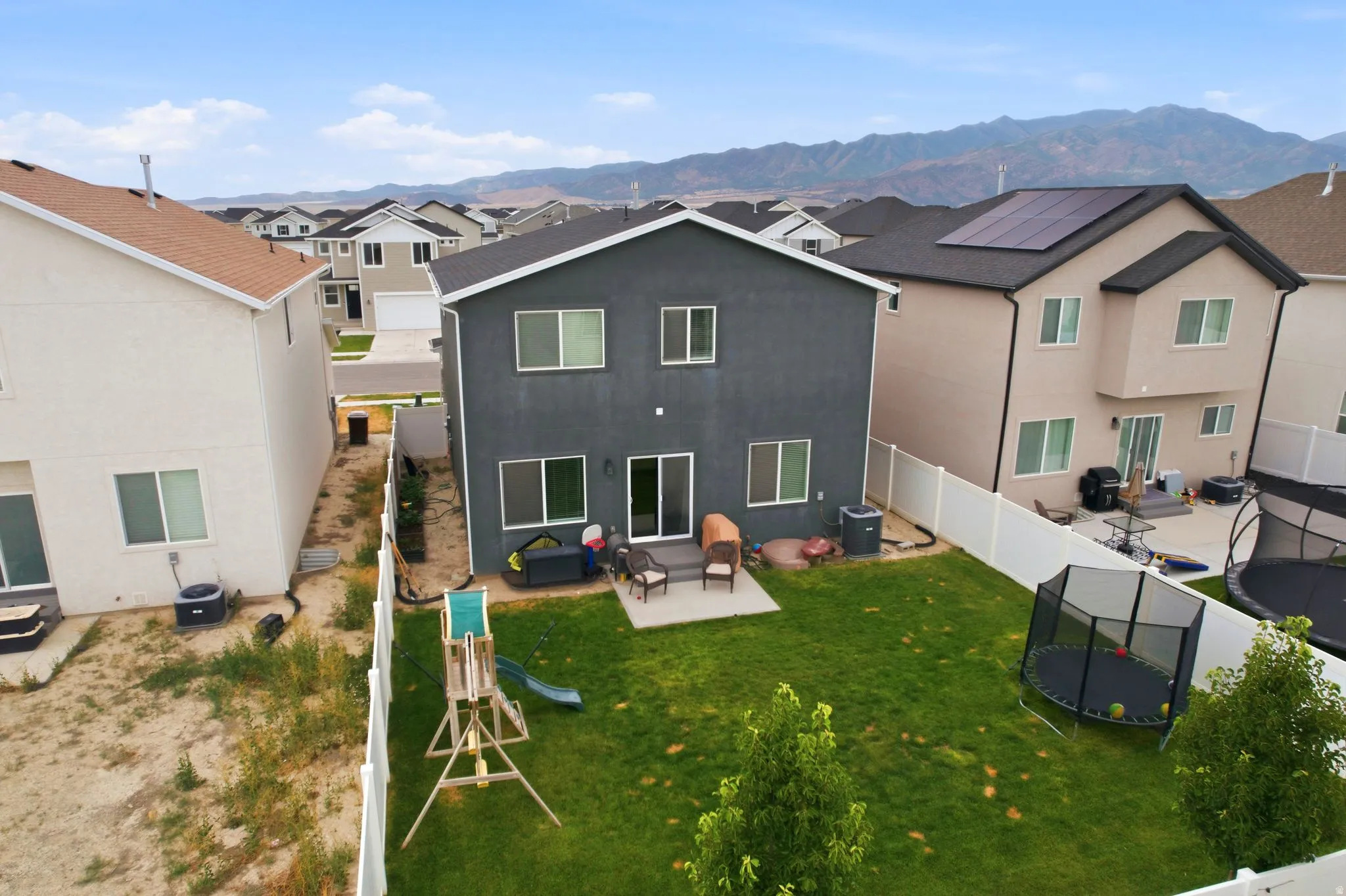 Rear exterior featuring a patio, sliding glass door, and multiple windows