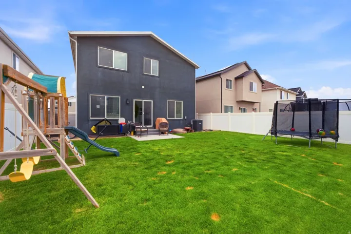 Spacious backyard featuring a manicured lawn, a concrete patio, and a privacy fence