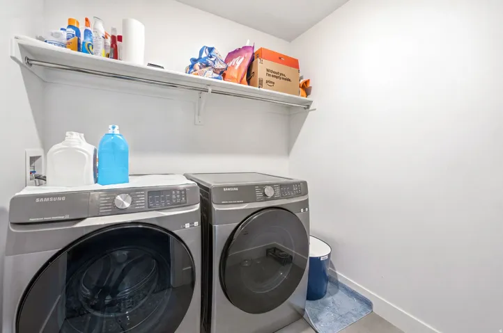 Dedicated laundry area featuring a white wall shelf, a hanging rod, and light-colored flooring
