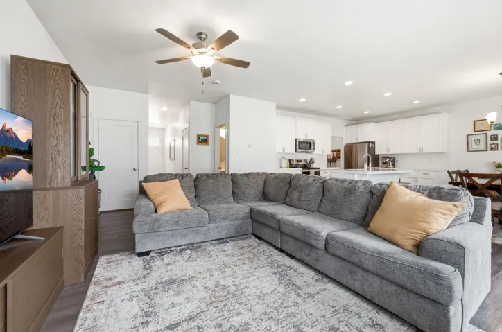 Open-concept living space featuring wood-finish flooring, a ceiling fan, and recessed lighting