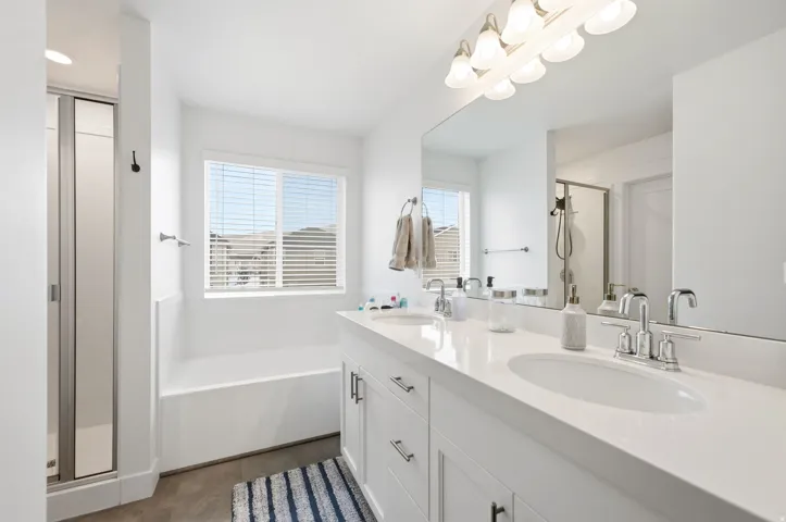 Dual vanity with white cabinetry and integrated sinks, complemented by chrome fixtures