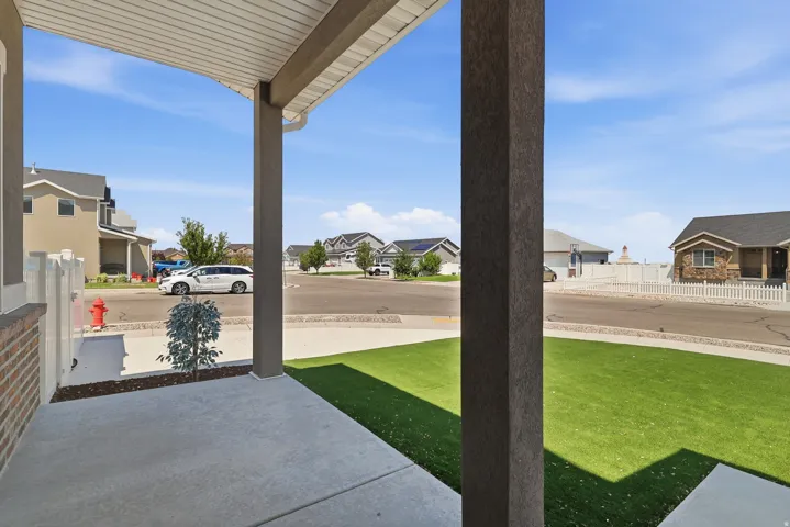 Covered front porch with concrete flooring and stucco-finished columns