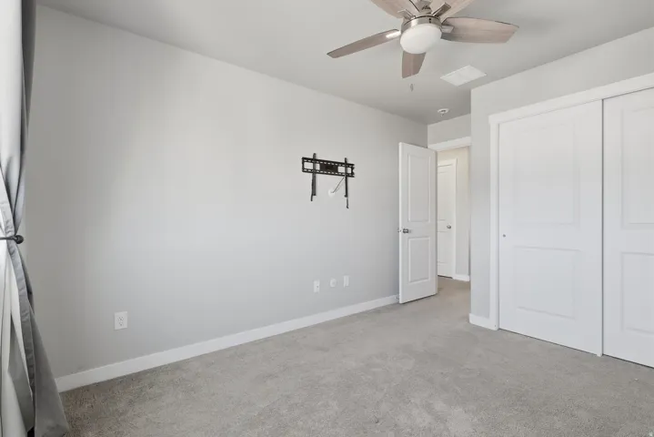 Room featuring light gray walls, gray carpeting, and white baseboards
