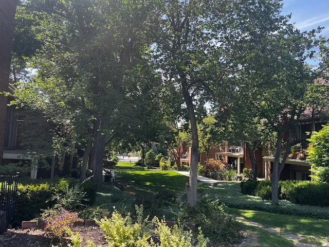 Lush green landscaping with mature trees and maintained shrubbery