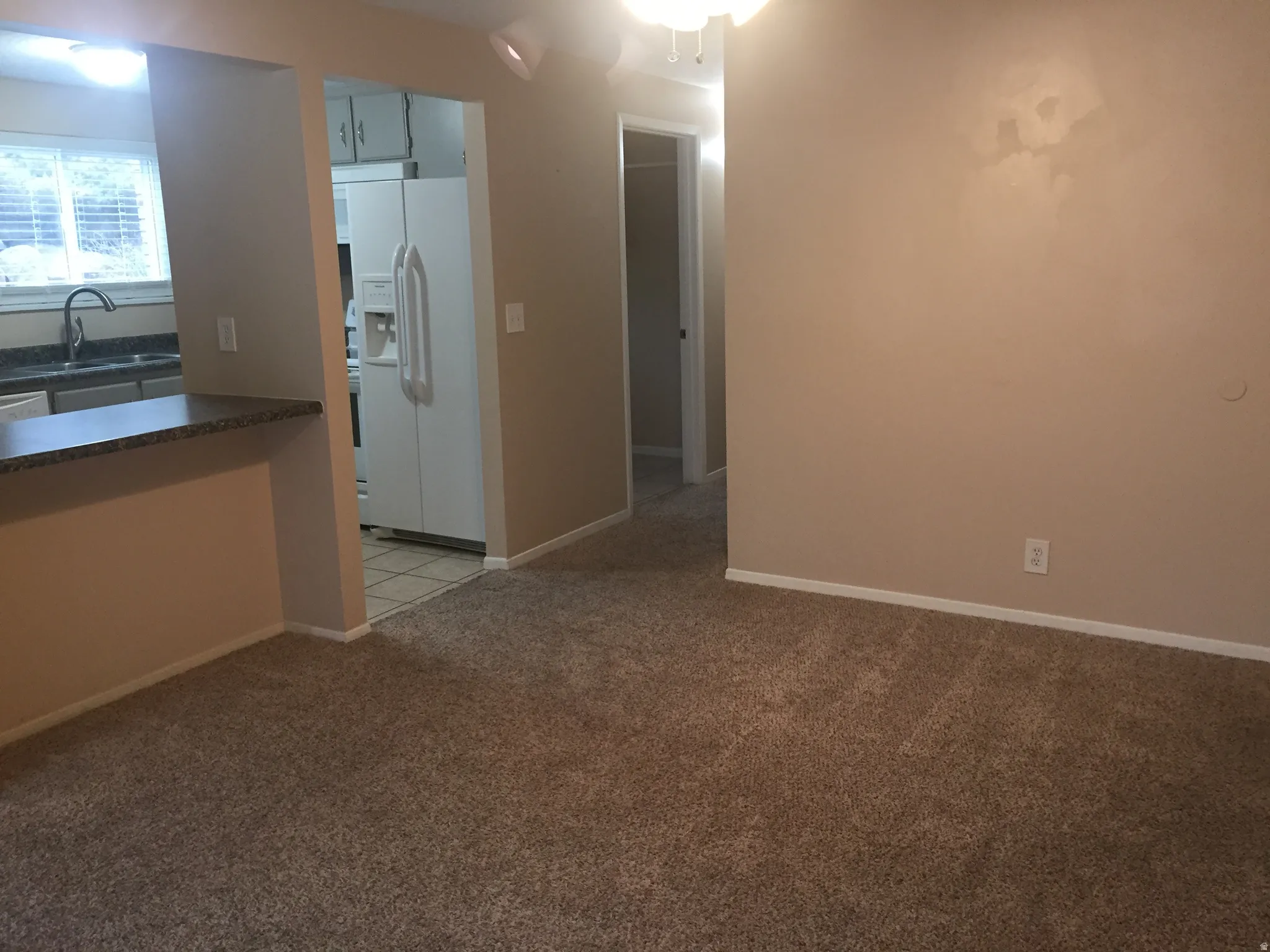 Spacious room with plush carpeting, neutral wall tones, and white trim