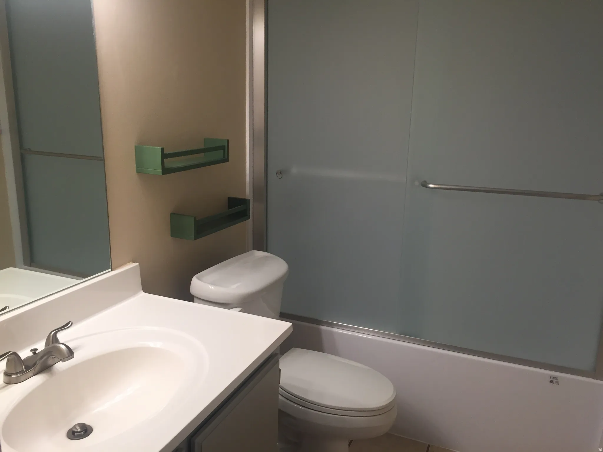 Bathroom featuring a single vanity with a white countertop, an undermount sink, and a brushed nickel faucet