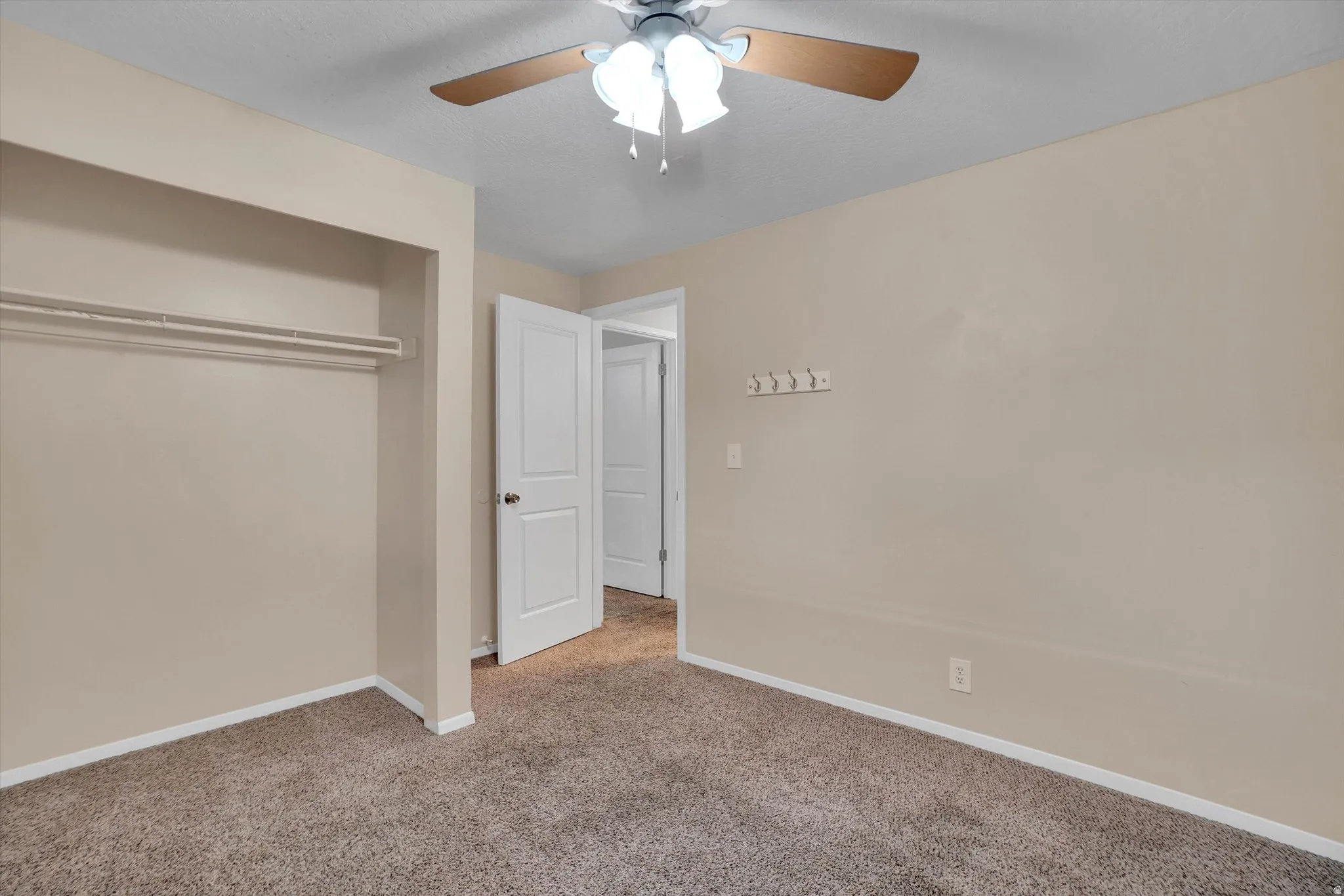 2nd bedroom has Neutral-toned walls complement plush carpeting