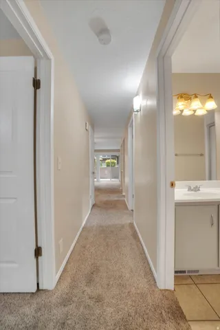 Hallway featuring carpet flooring, recessed lighting, and white panel doors