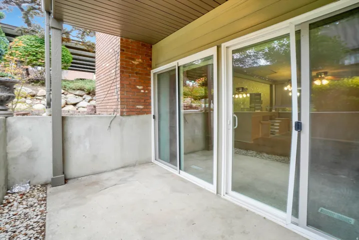 Covered concrete patio with white-framed sliding glass doors