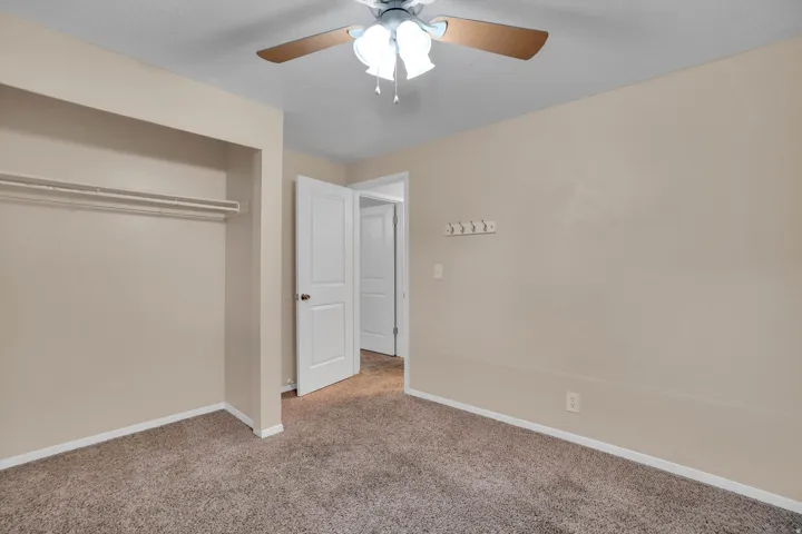 2nd bedroom has Neutral-toned walls complement plush carpeting