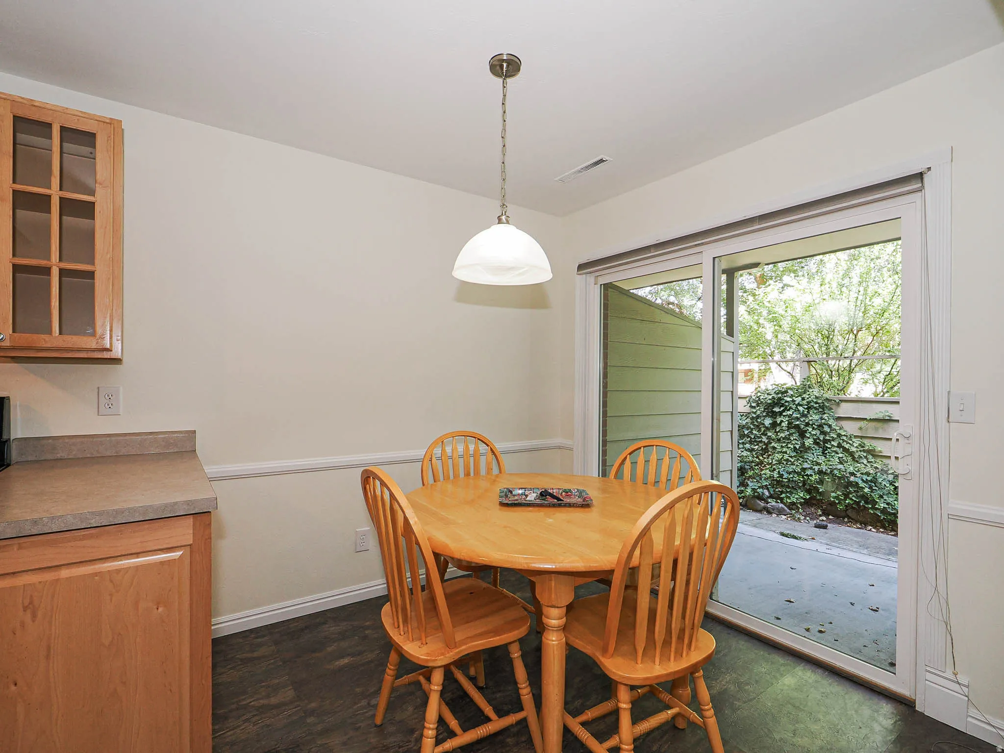Dining area featuring wood-finish flooring and a contemporary pendant light fixture