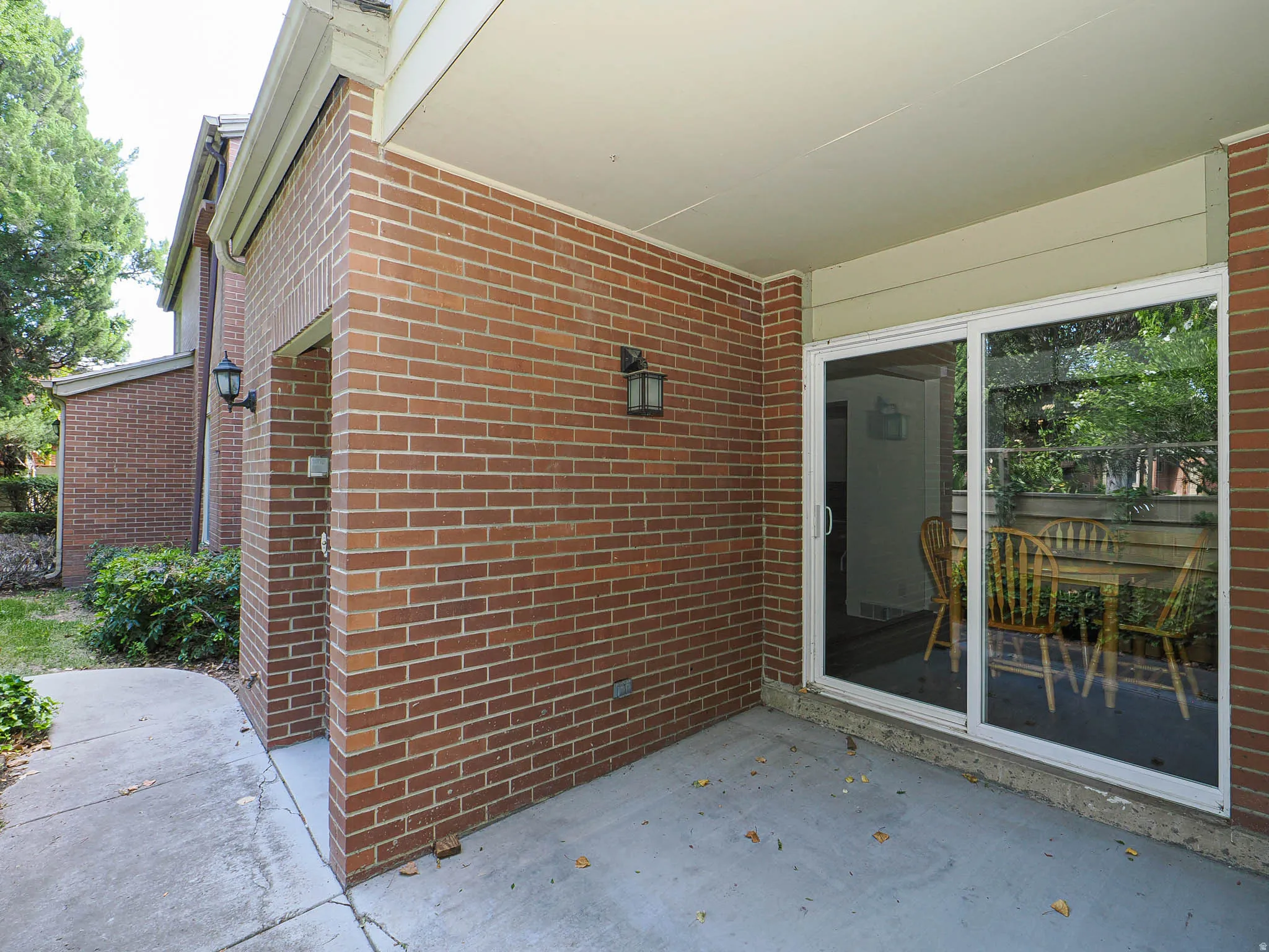 Covered patio featuring a concrete surface and brick exterior walls