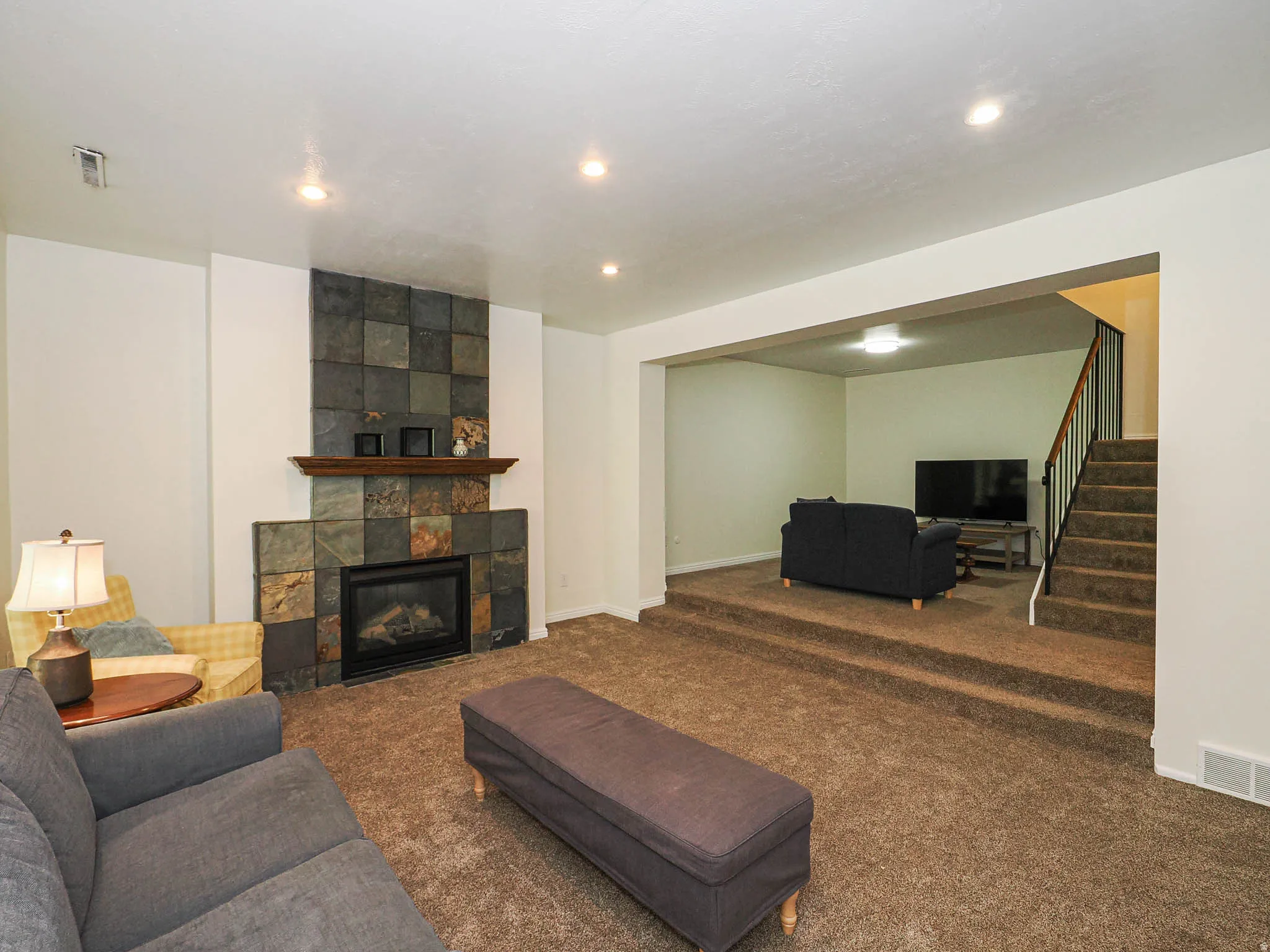 Living area featuring a stone tile fireplace with a wood mantel