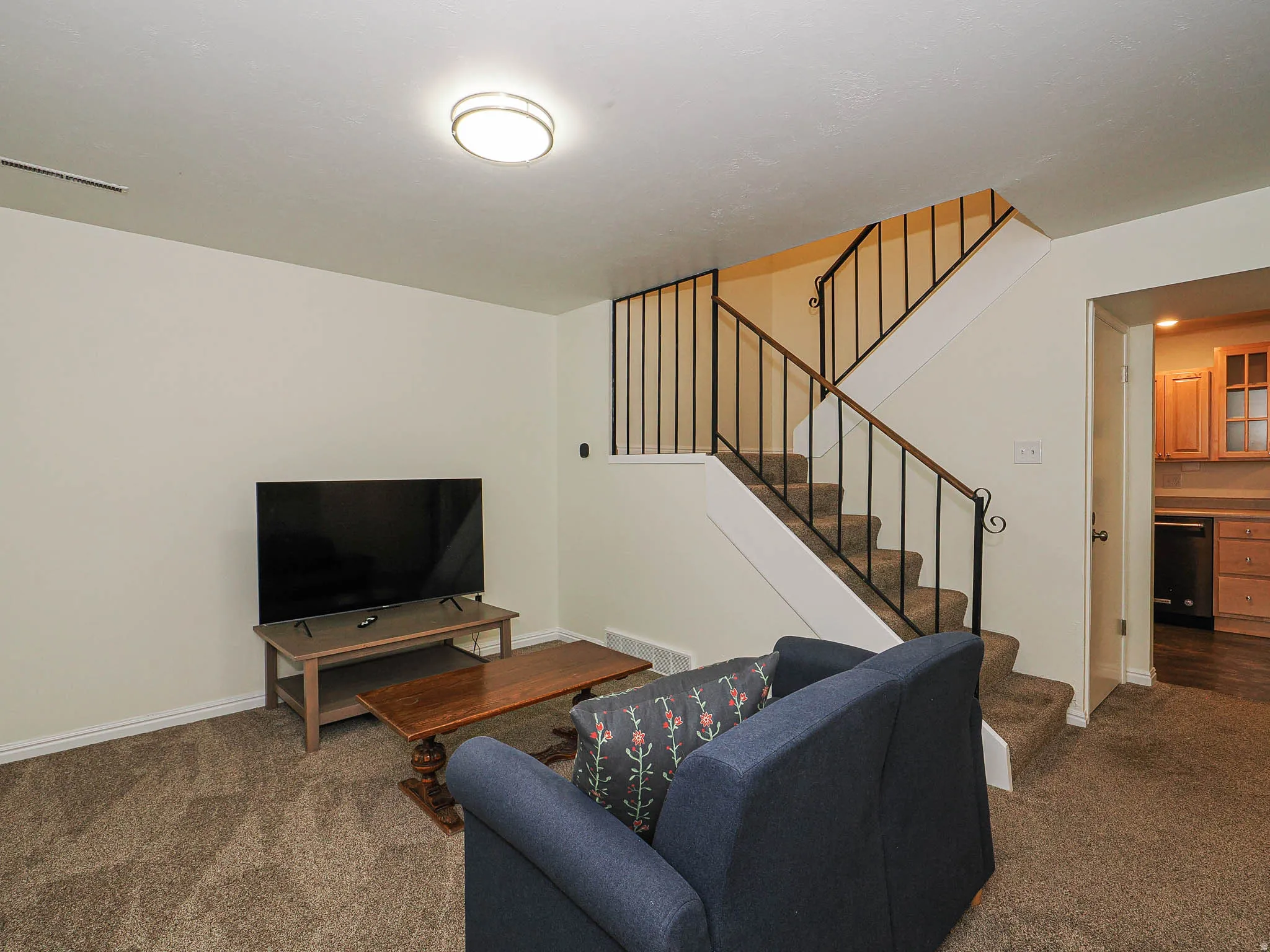 Staircase with wrought iron balusters and carpeted treads