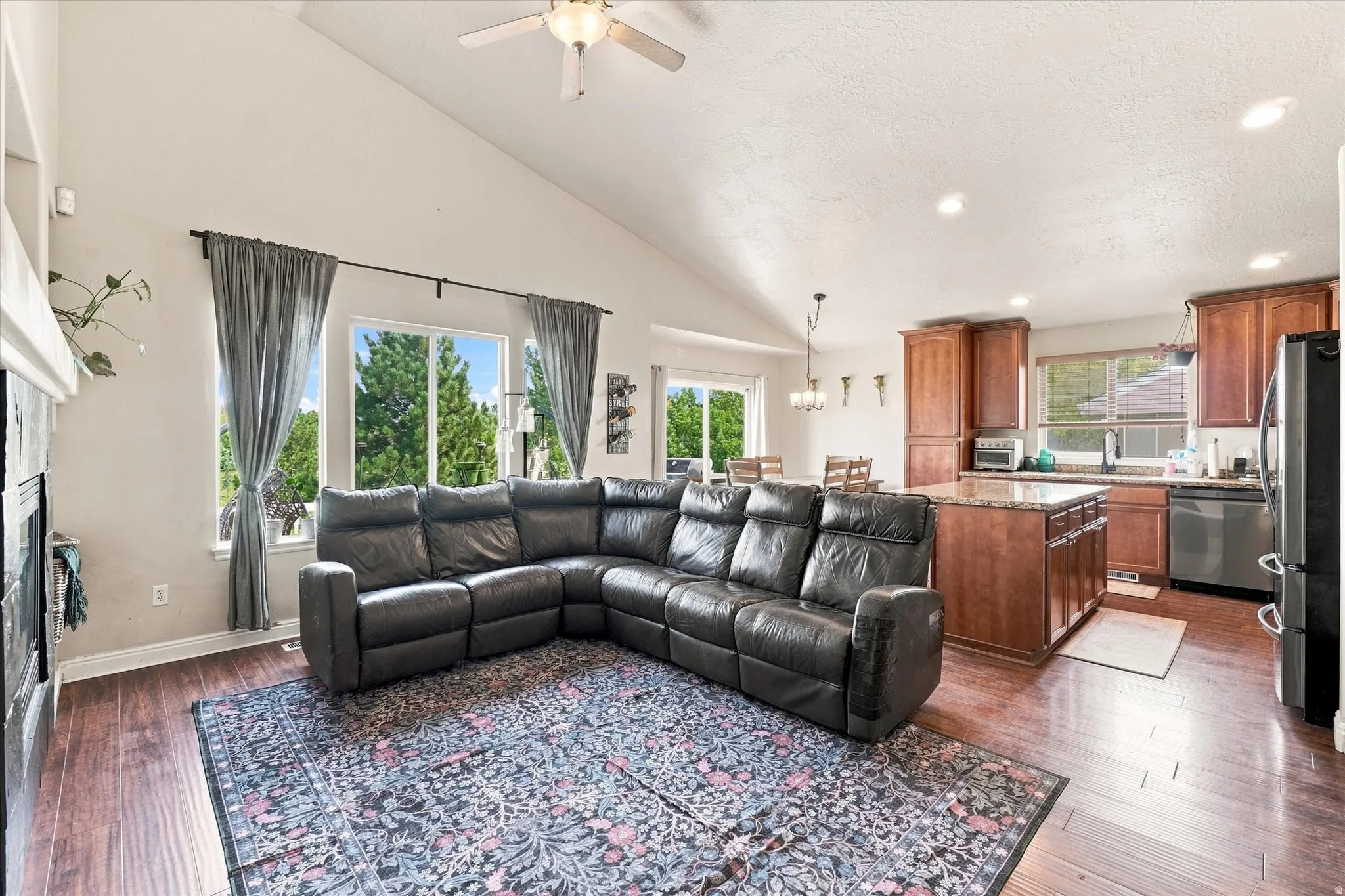 Vaulted ceilings complement wood-finish flooring in this open-concept living area