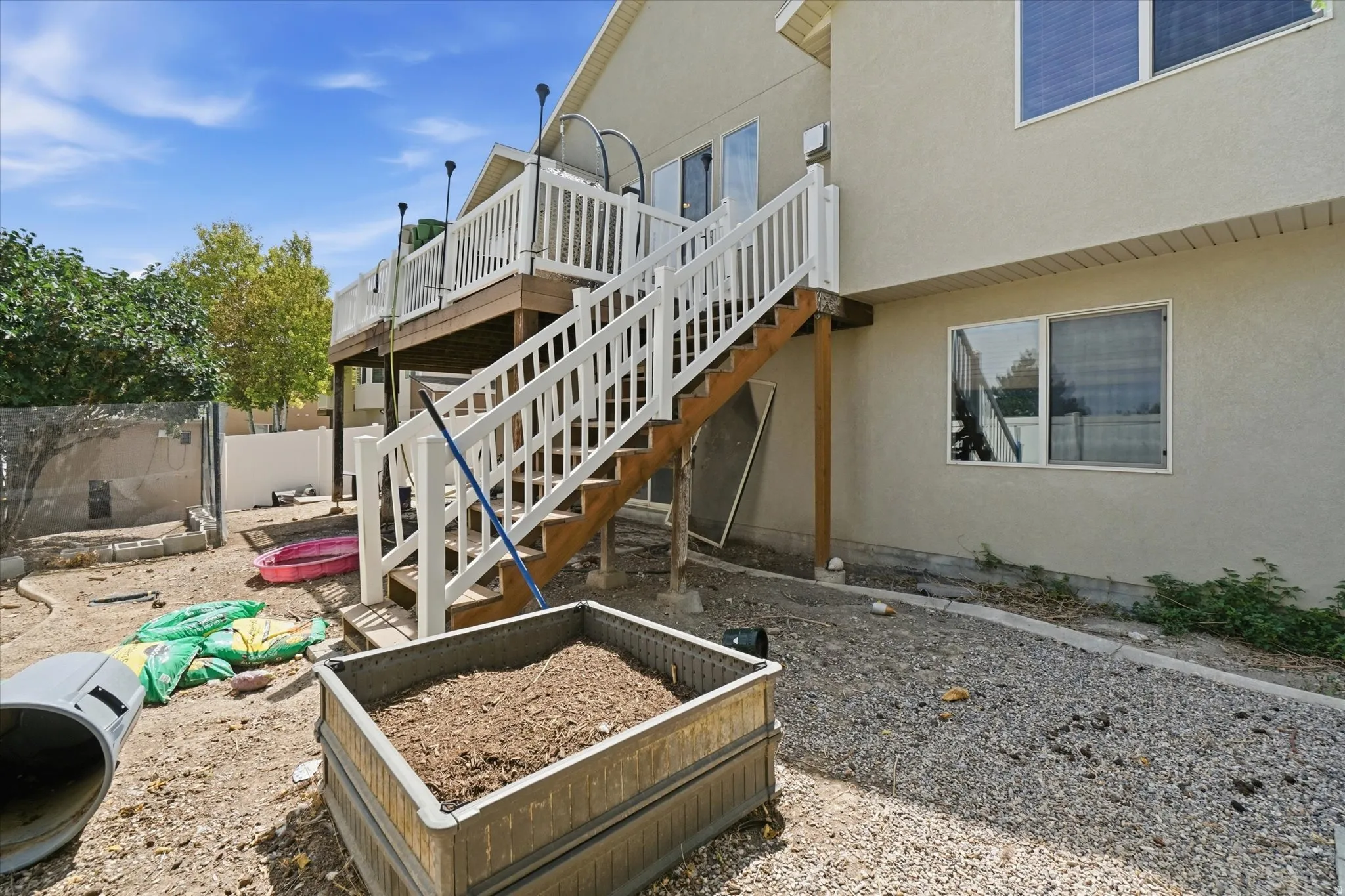 Multi-level deck with white railings and wood-finish stairs