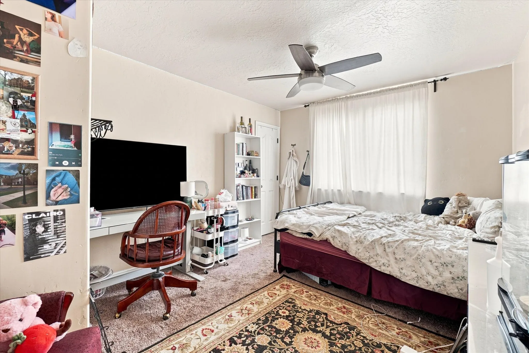 Bedroom #3 featuring a ceiling fan, a window with white drapes, and light-colored walls