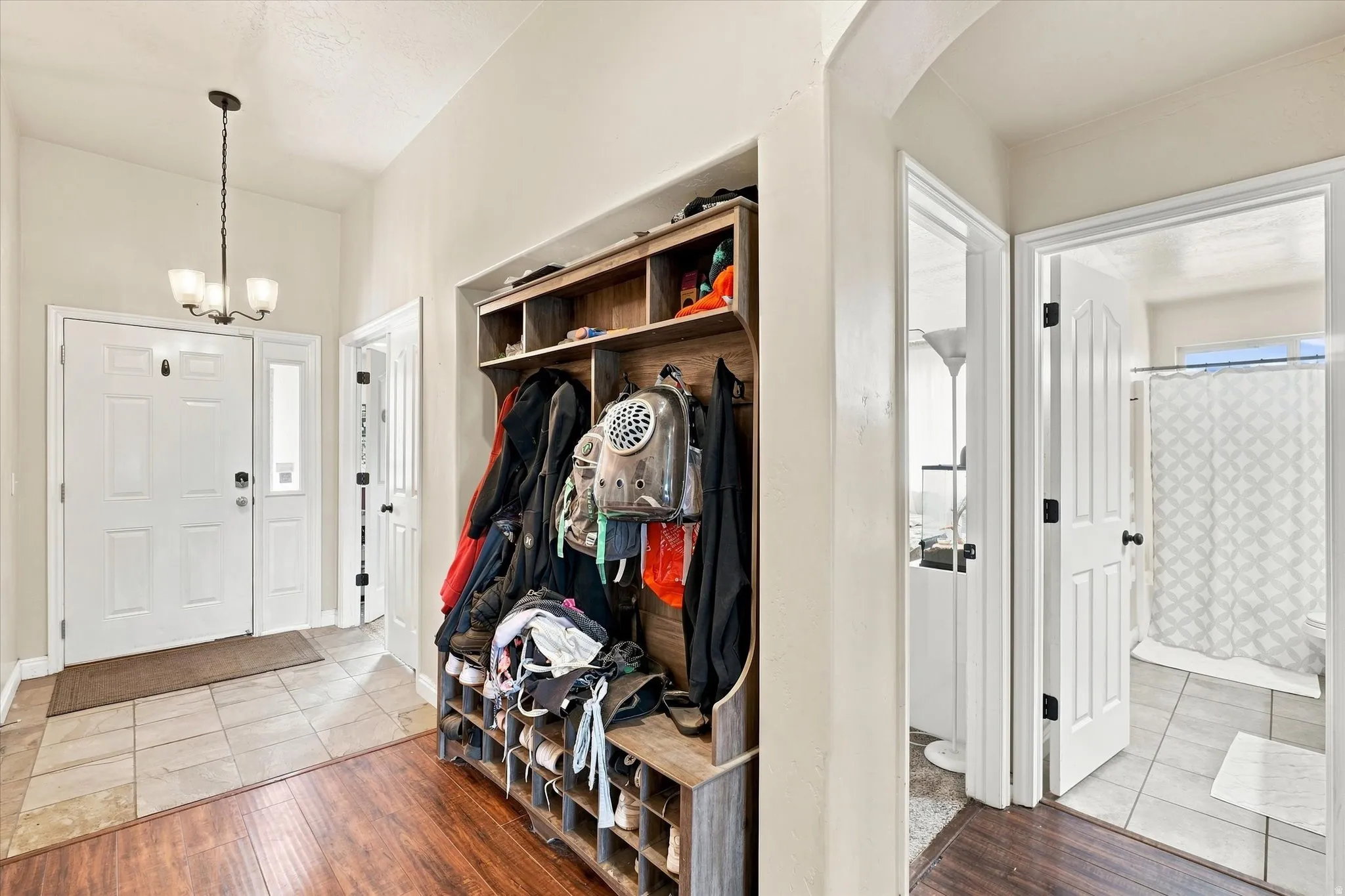 Foyer featuring wood-finish flooring, tile entryway, main bathroom