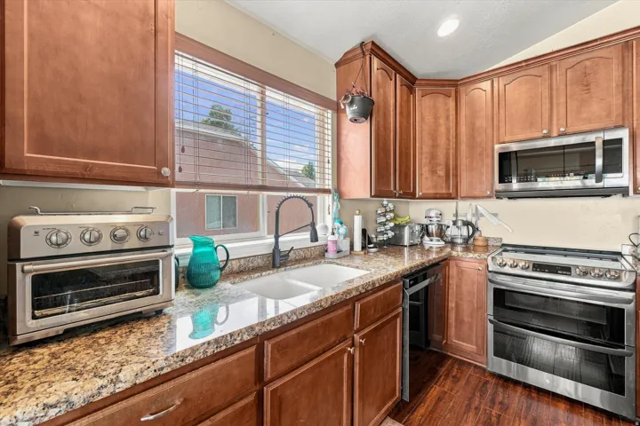 Kitchen featuring rich wood cabinetry and granite-style countertops