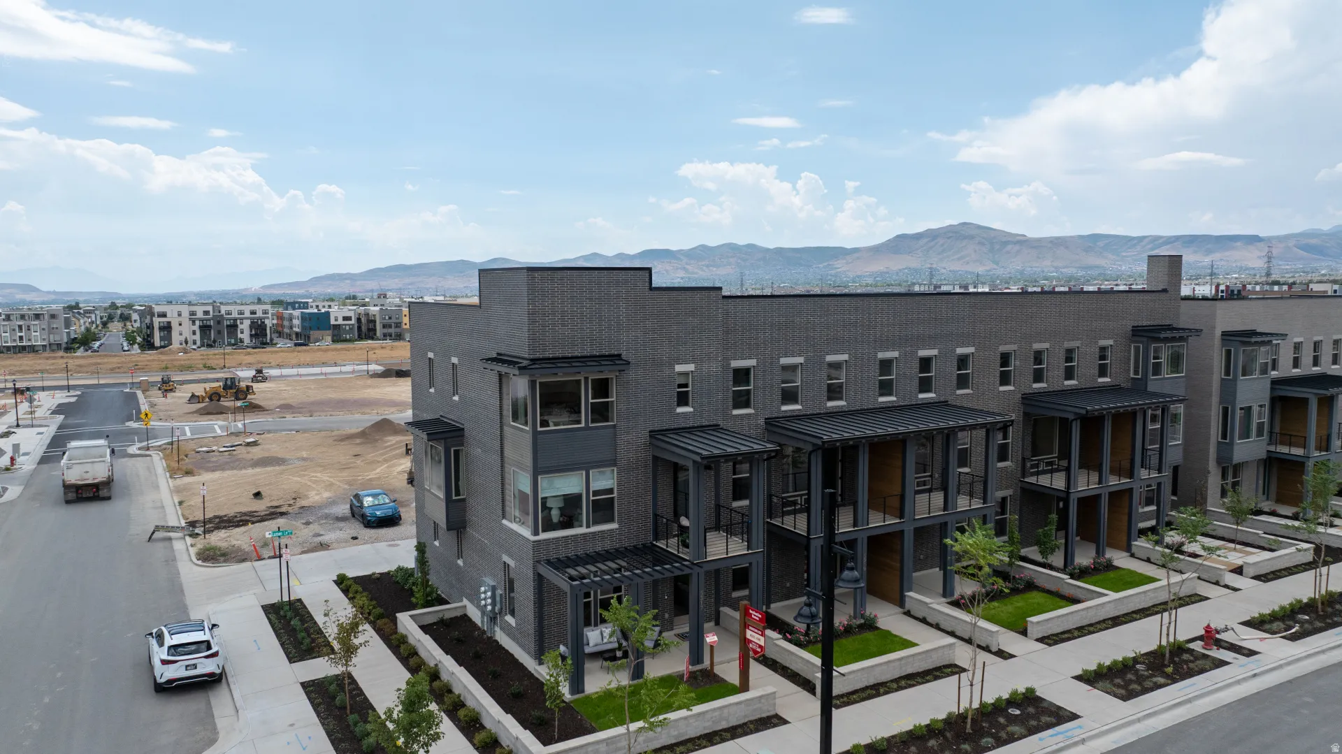 Modern townhome-style residences featuring dark brick and panel siding