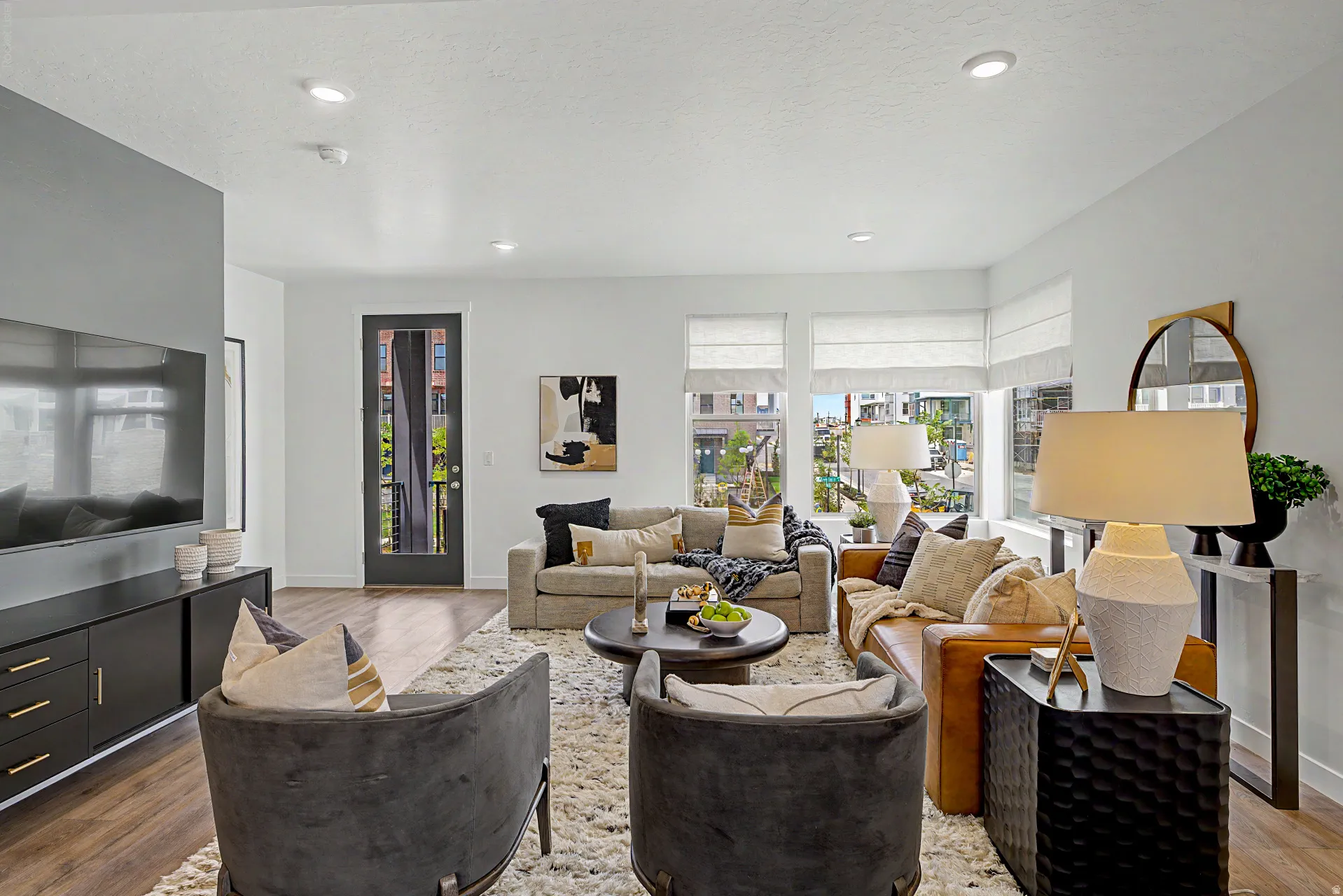 Spacious living area featuring wood-finish flooring, recessed lighting, and expansive windows