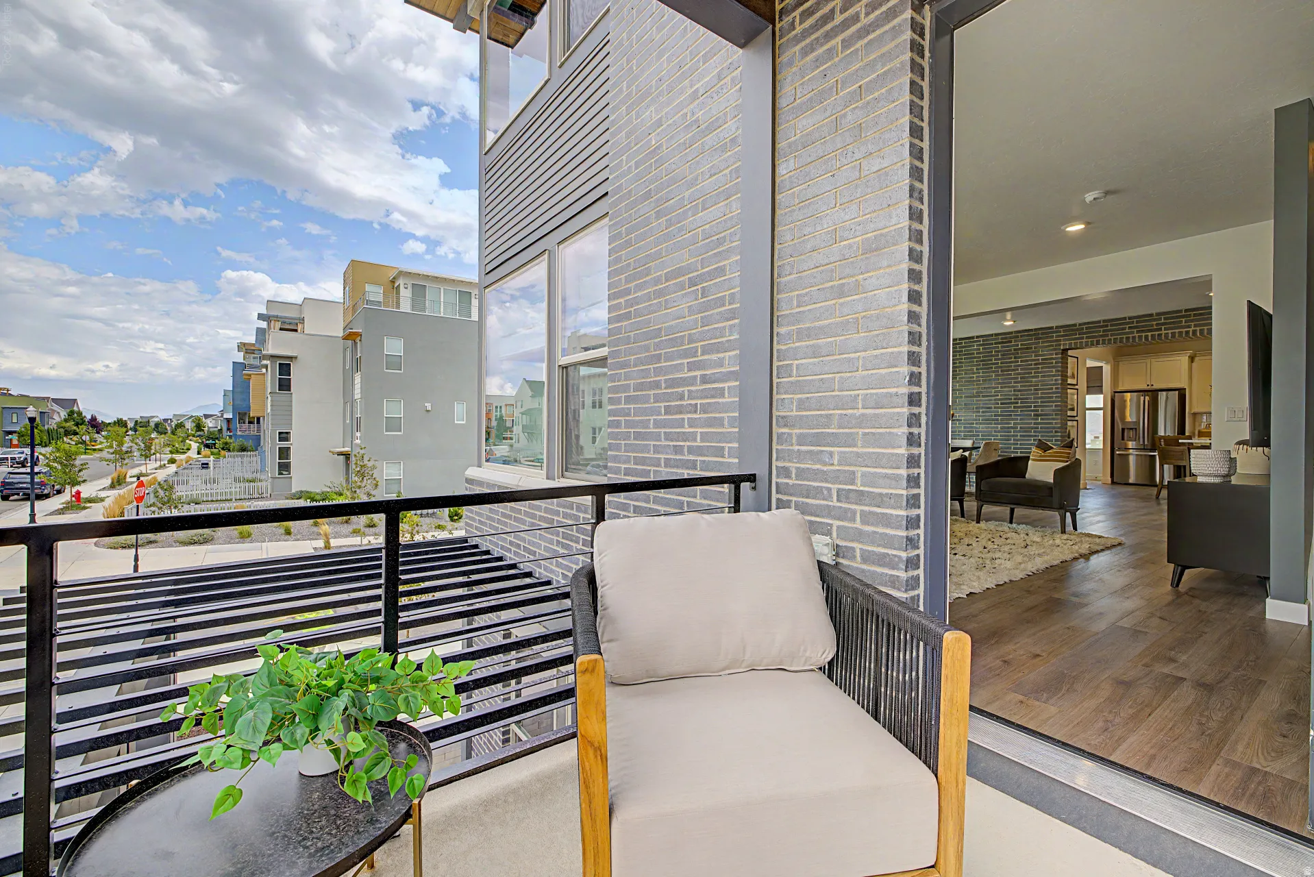 Private balcony featuring a black metal railing and grey brick exterior