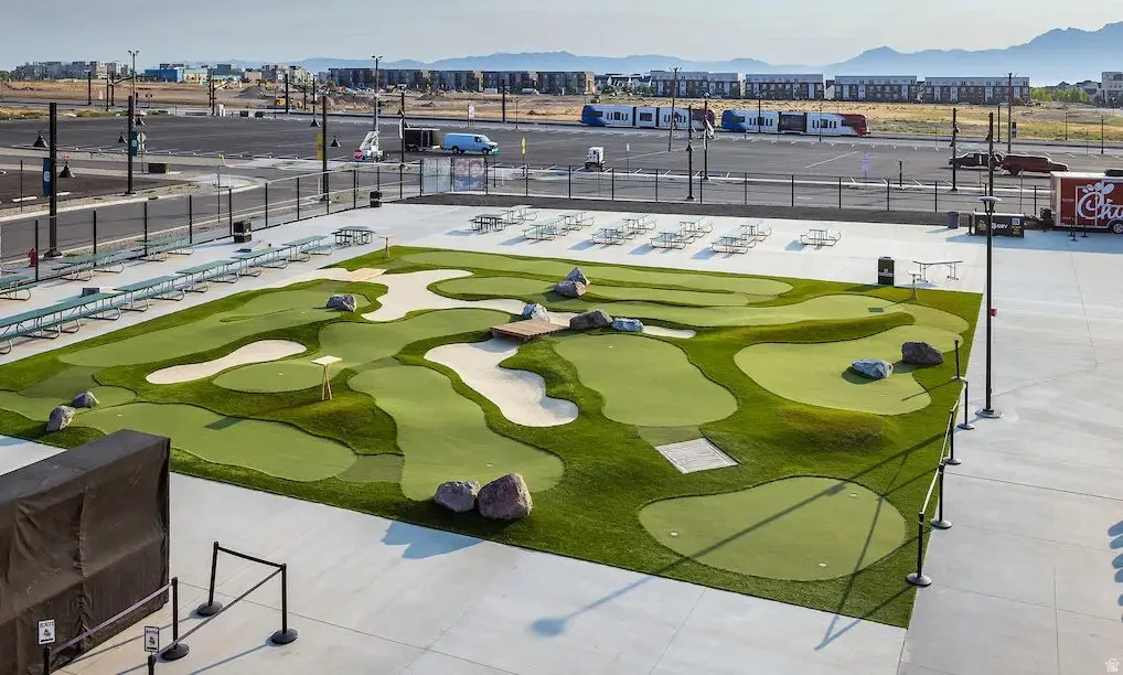 Multi-hole putting green featuring artificial turf, sand traps, and decorative boulders