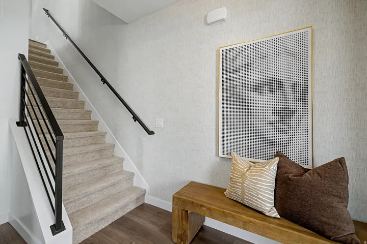 Carpeted staircase with dark metal railings