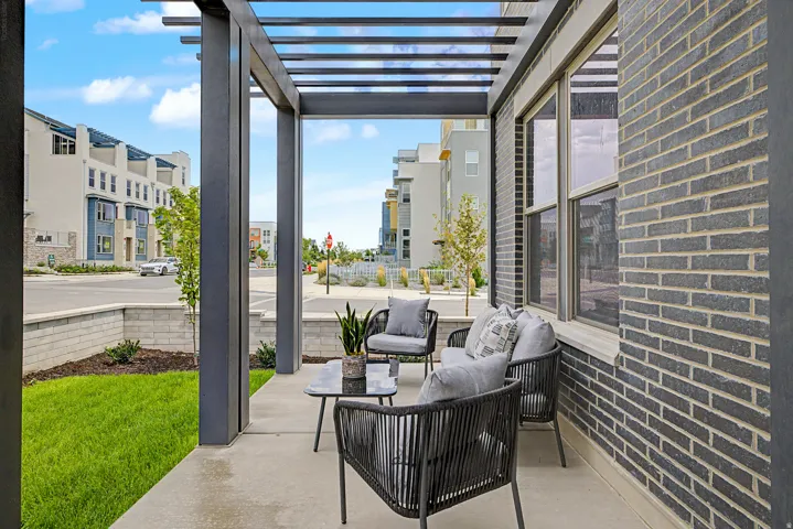 Covered patio featuring a slatted metal pergola and concrete flooring