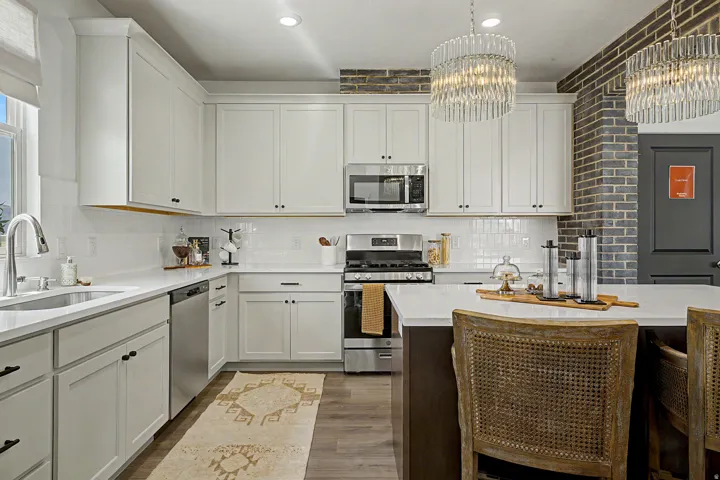 Modern kitchen featuring white shaker cabinetry, stainless steel appliances, a subway tile backsplash, and wood-finish flooring