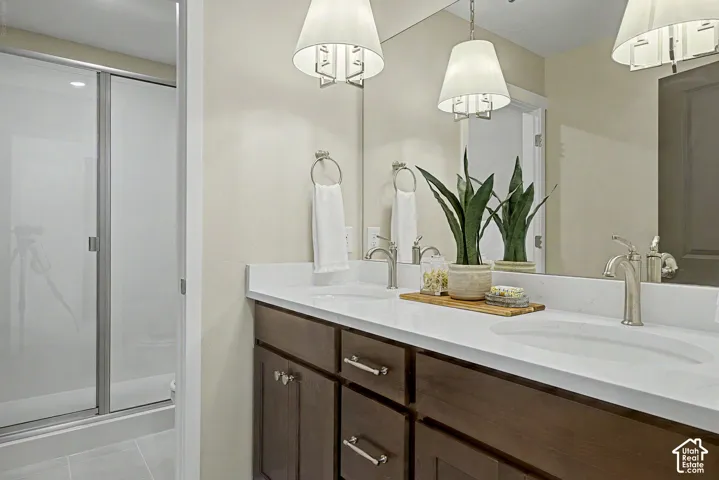 Bathroom featuring a double vanity with stone countertops, undermount sinks, and brushed nickel fixtures