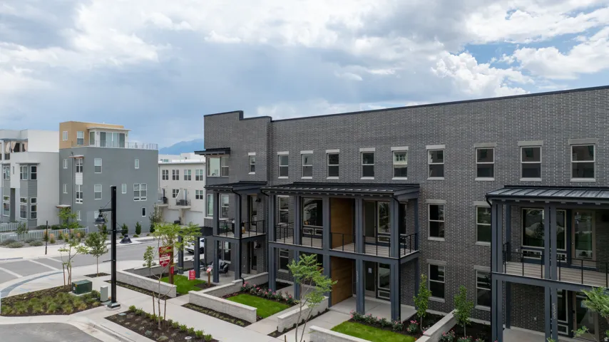Modern multi-story building featuring a dark gray brick facade and contrasting black window frames