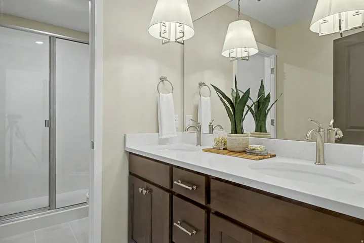 Bathroom featuring a double vanity with stone countertops, undermount sinks, and brushed nickel fixtures