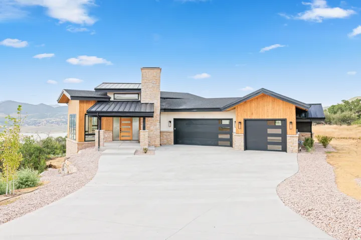 Contemporary single-story residence featuring a stone and wood panel exterior