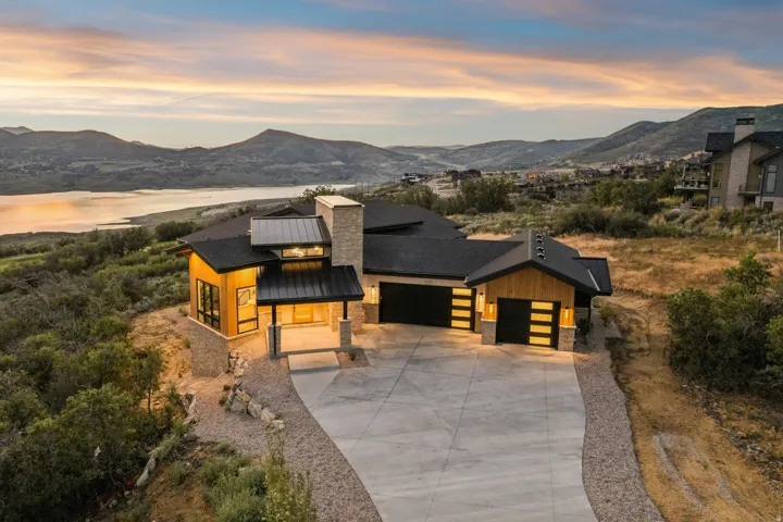 Contemporary residence featuring a prominent stone chimney and wood-finish siding accents