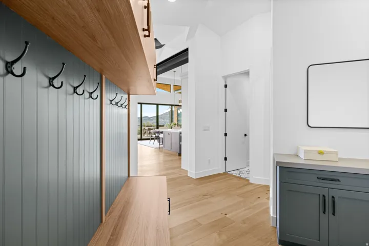 Entryway featuring wood-finish flooring in a herringbone pattern and a custom built-in mudroom bench