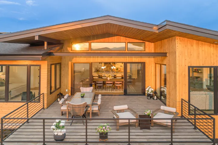 Expansive outdoor deck featuring wood-finish siding and dark-framed windows
