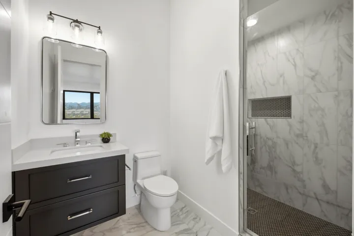 Contemporary bathroom featuring a dark wood-finish floating vanity with a white countertop and rectangular undermount sink