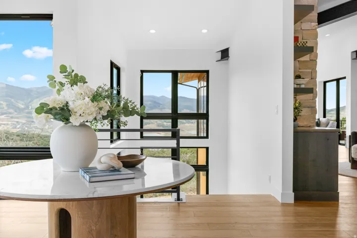 Modern entryway featuring a round console table with a marble-finish top and a light wood-tone base