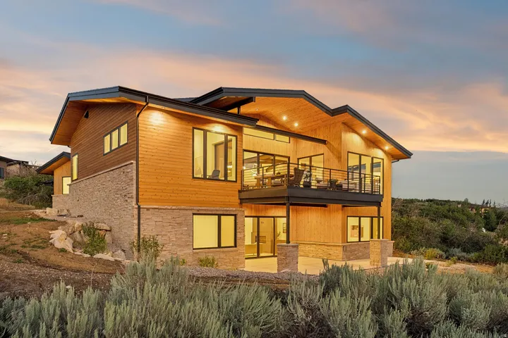 Modern exterior featuring warm wood-finish siding and stacked stone accents