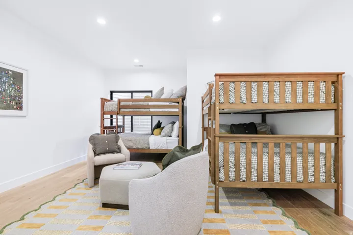 Spacious room featuring light wood-finish flooring, recessed lighting, and white walls