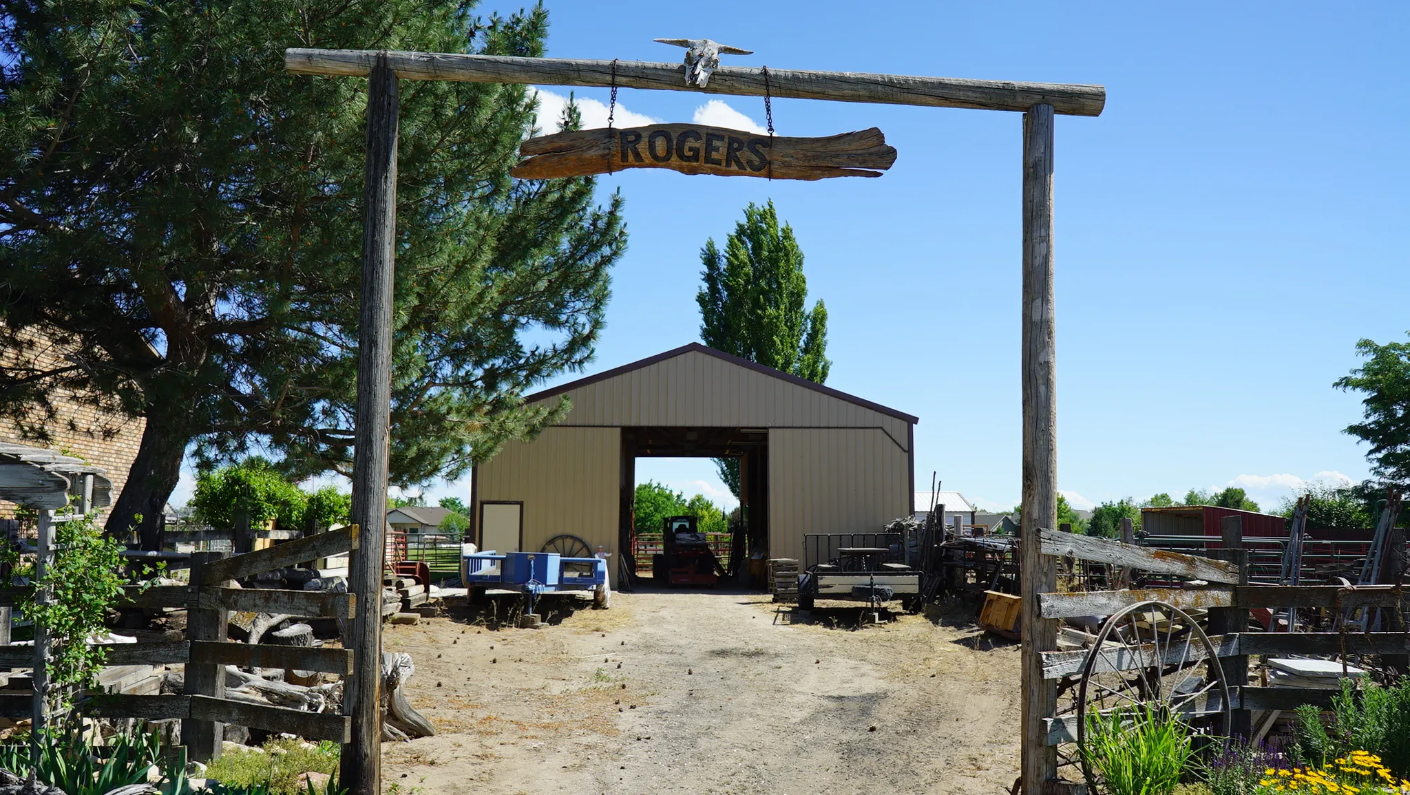 Barn structure with a large open entrance, light tan metal siding, and a dark brown roof