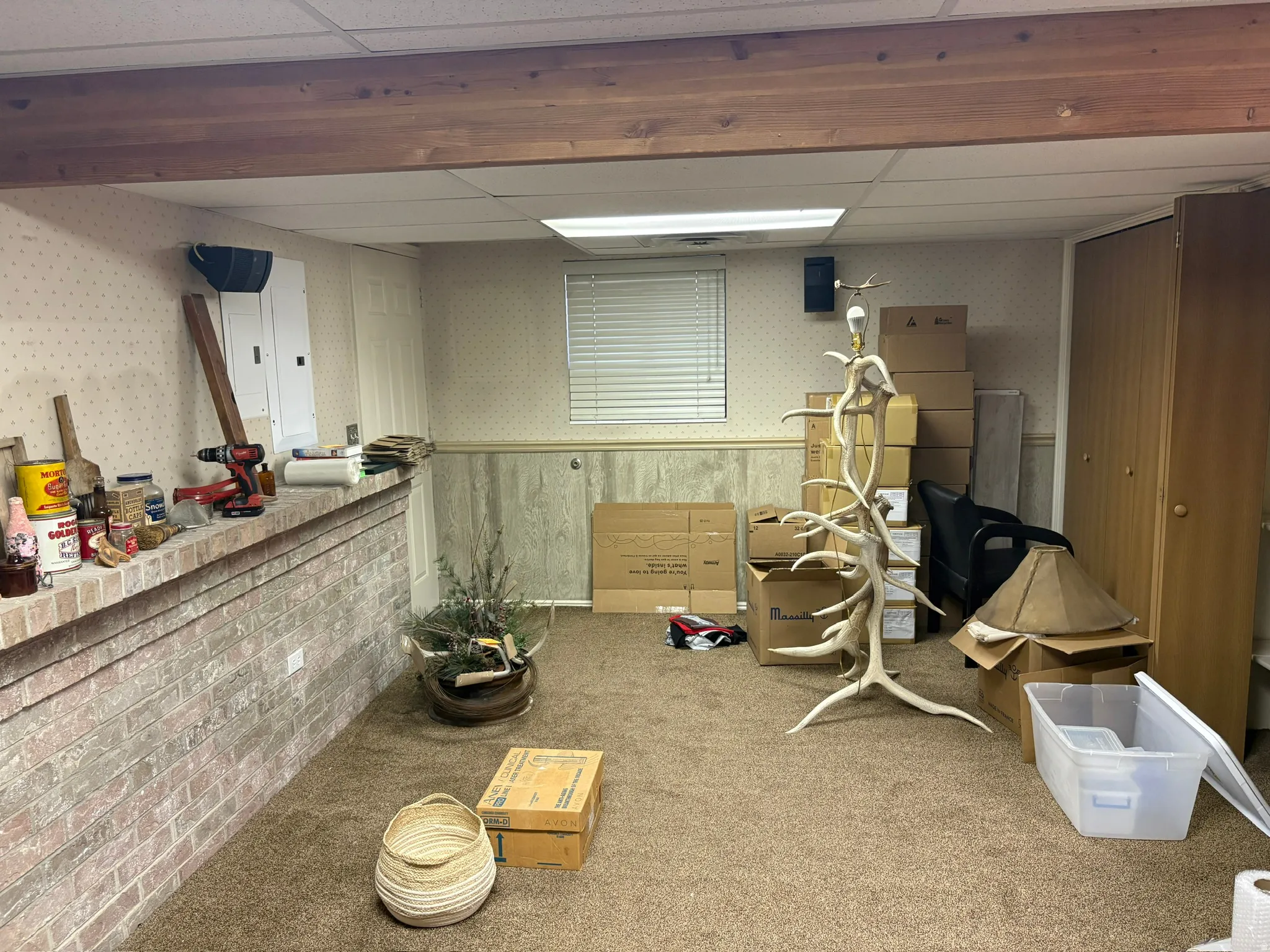 Carpeted room featuring a brick half-wall, a built-in closet with double doors, and a single window with horizontal blinds