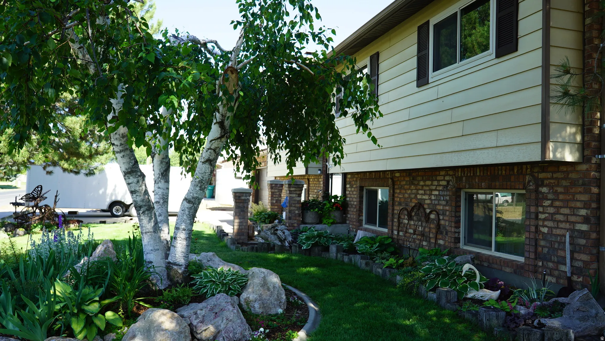 Split-level residence featuring a brick lower level and horizontal siding on the upper level