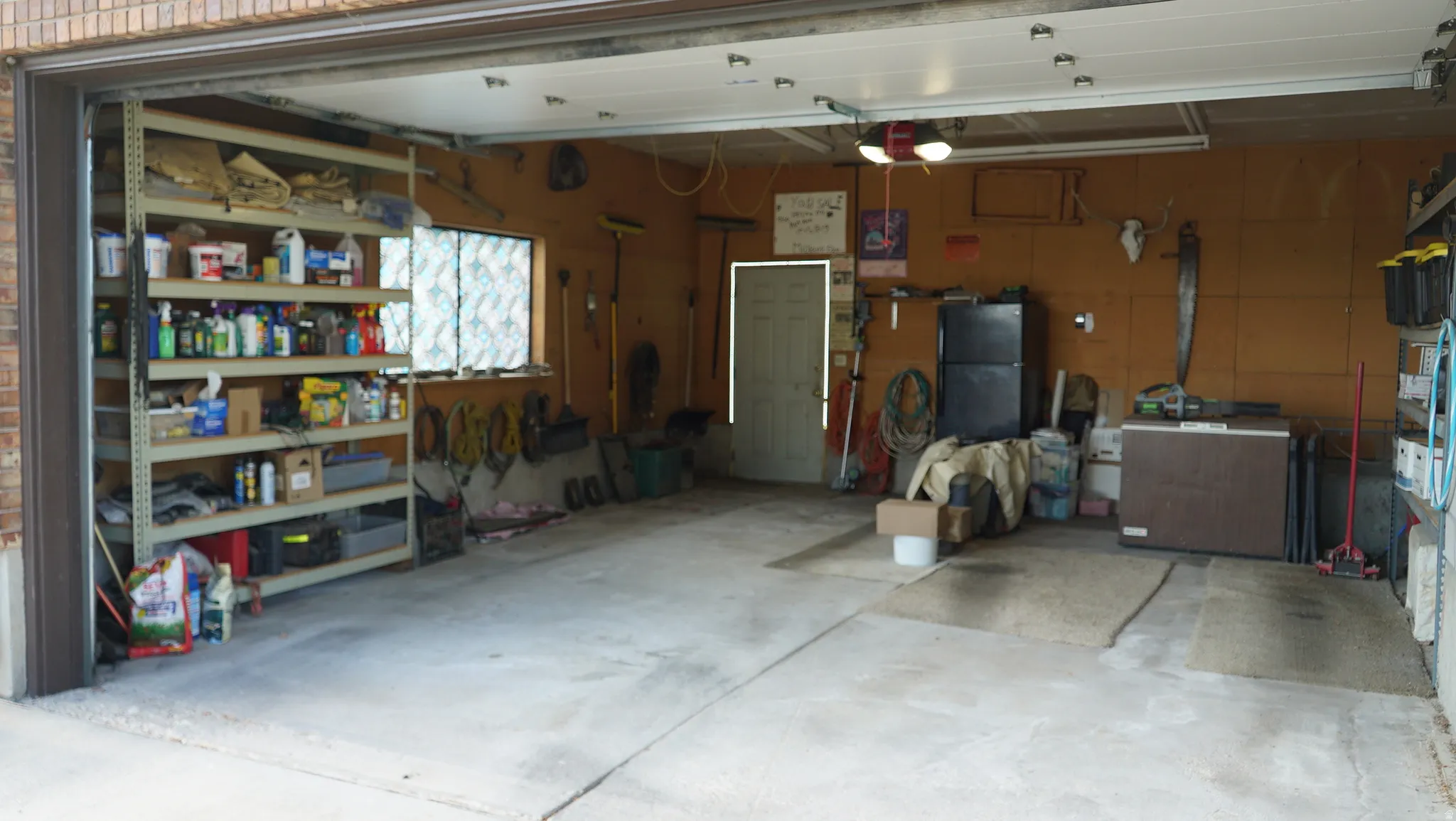 Spacious garage featuring concrete flooring, an accessible entry door, and a dedicated window providing natural light