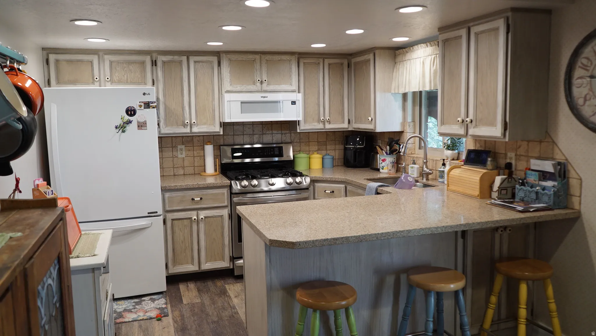 Kitchen featuring overhead recessed lighting, wood-finish flooring, and a breakfast bar