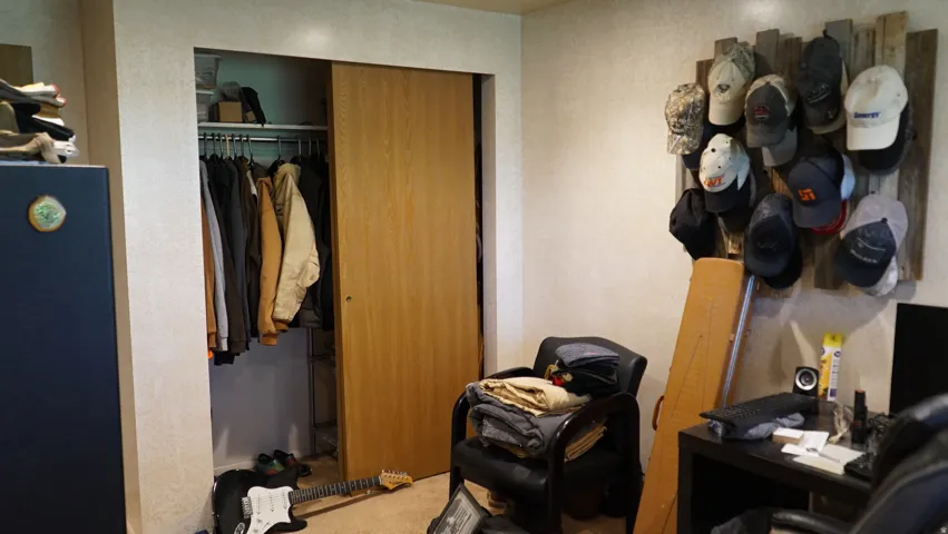 Recessed closet with natural wood-finish sliding doors and a built-in hanging rod