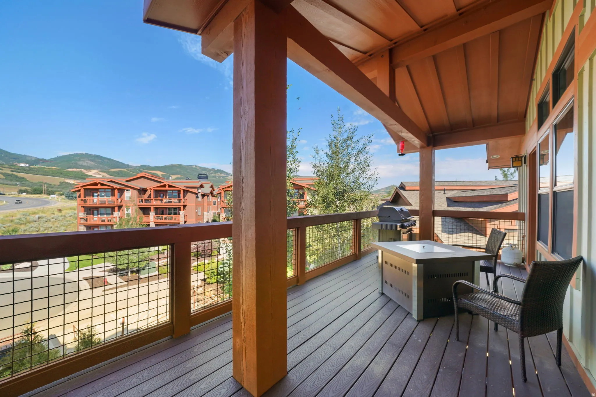 Spacious covered deck featuring a wood-finish ceiling, exposed beams, and composite decking